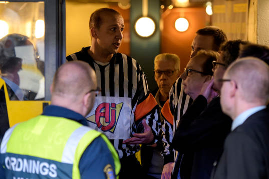 Domaren i diskussion med lagens ledare angående