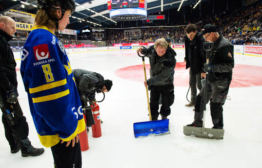 Arenapersonal försöker laga en isskada