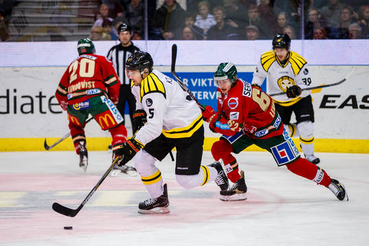 Brynäs Lukas Kilström med pucken jagas av Frölundas