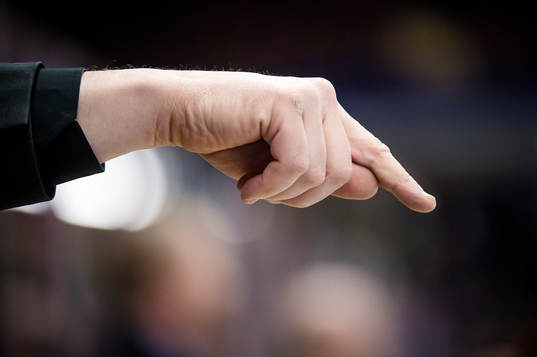 En tränare pekar neråt med sitt finger