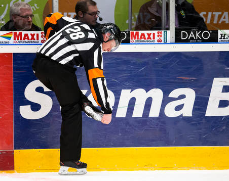 Domare Mikael Holm kollar skenan på skridskorna