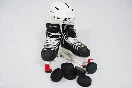 En ishockeyhjälm, två skridskor, och några puckar