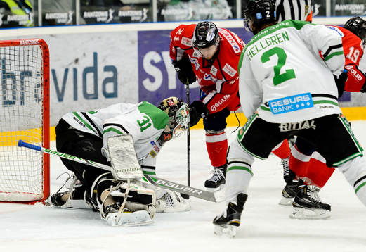 Rögles målvakt Lars Volden blockerar pucken  framför
