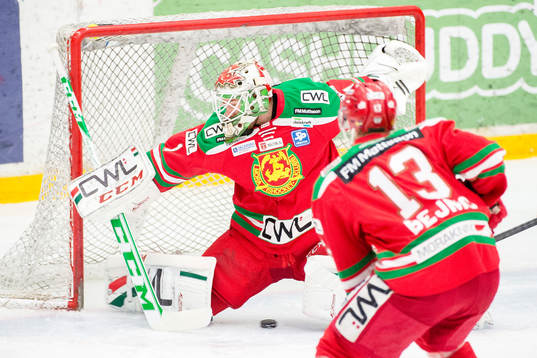 Puck passerar mellan benen på Moras målvakt Dan Bakala