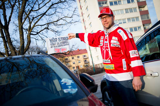 Örebrosupporter håller upp en bilvimpel med texten Vår