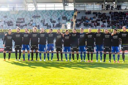 Båda lagen bär tröjor med texten "Tillsammans mot