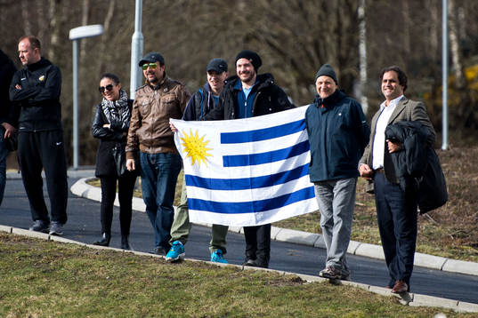 Några supportrar håller upp Uruguays flagga