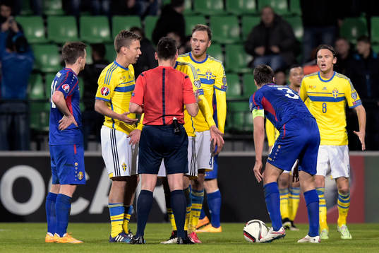 Domaren Ivan Bebek pratar med Sveriges Andreas Granqvist