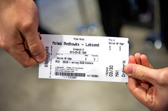 En åskådare håller en matchbiljett