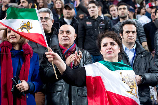 Iranska supportrar håller upp en flagga med ett lejon på