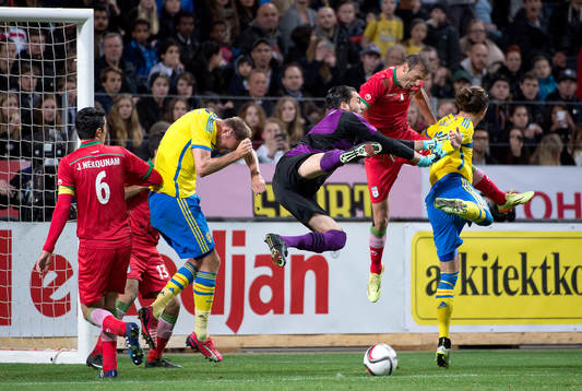 Irans målvakt Alireza Haghighi räddar framför Sveriges