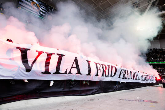 Hammarbys supportrar med en banderoll och bengaler