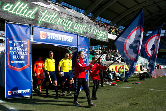 Lagen går in på arenan innan en fotbollsmatch i
