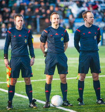 Domare Kristoffer Karlsson (m), med linjedomare Björn