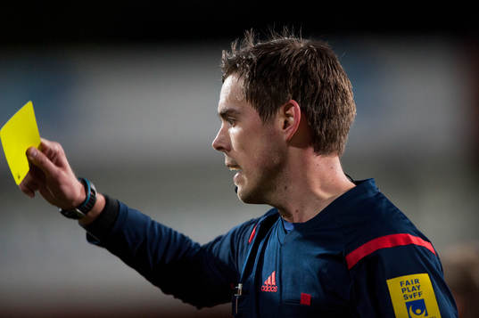 Domaren Magnus Lindgren visar gult kort i matchen i