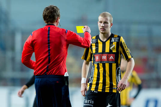 Domare Markus Strömbergsson delar ut ett gult kort till