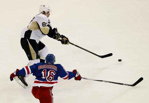 Pittsburgh Penguins Sidney Crosby (L) passees the puck past