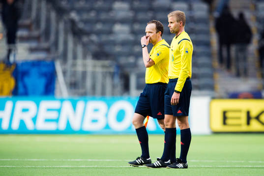 Domare Glenn Nyberg pratar med linjedomare