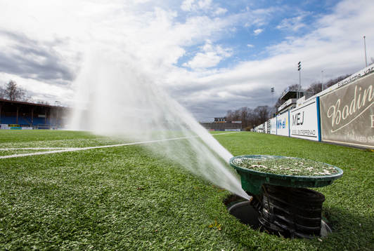 En vattensprinkler bevattnar konstgräset
