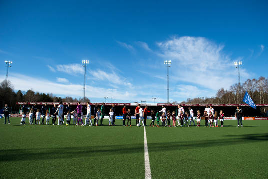 Lagen hälsar på varandra innan en fotbollsmatch i