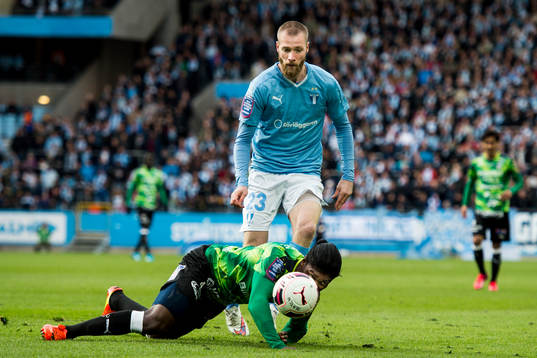 Halmstads Joseph Baffo faller framför Malmö FFs Jo Inge