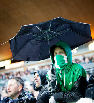 Maskerad Hammarbysupporter med i ett trasigt paraply i