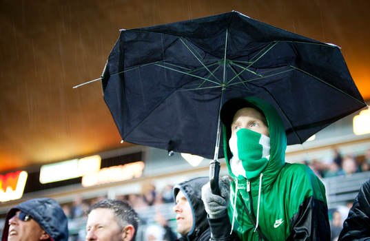 Maskerad Hammarbysupporter med i ett trasigt paraply i