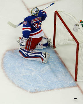 The puck bounces out of the net behind New York Rangers