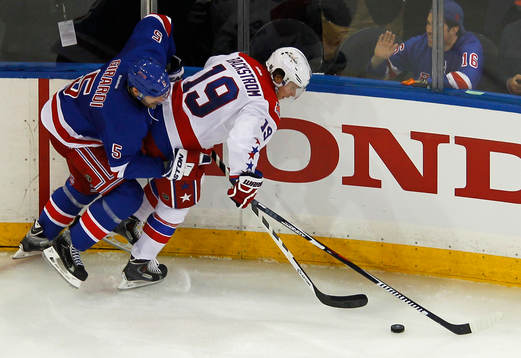 Washington Capitals Nicklas Bäckstrom (R) is checked by