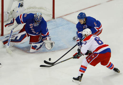 New York Rangers Jesper Fast (C) knocks the puck away from