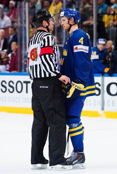 En av huvuddomarna pratar med Sveriges Staffan Kronwall med