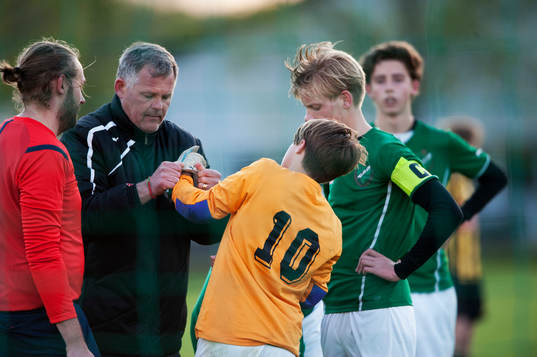 Målvakten får hjälp med handskarna i matchen för pojkar