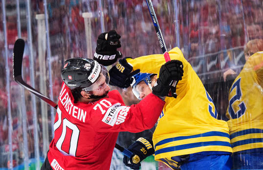 Schweiz Denis Hollenstein blir tacklad av Sveriges Jonas