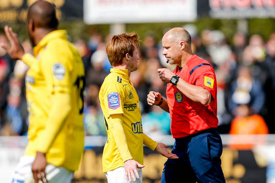 Matchens domare Martin Hansson ger en varning till