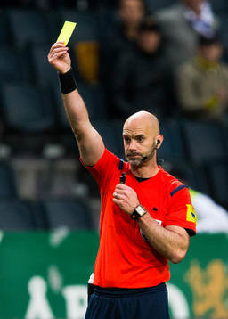 Domare Stefan Johannesson visar ett gult kort