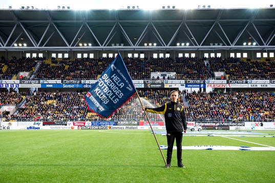 En kille håller en flagga från Svenska Spel och