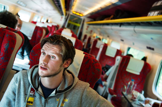 Oliver Ekman Larsson sitter på ett tåg när Sveriges