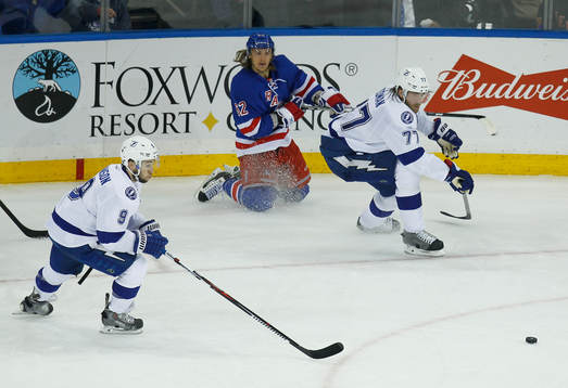 New York Rangers Carl Hagelin (C) passes the puck between