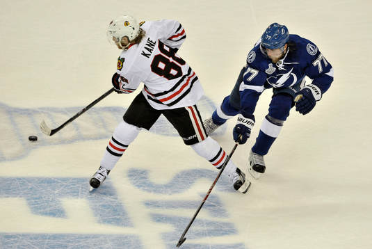 The Blackhawks' Patrick Kane (88) clears the puck from the