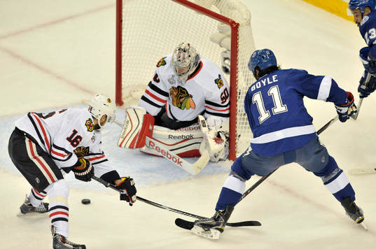 The Blackhawks' Marcus Kriger (16) helps goalie Corey