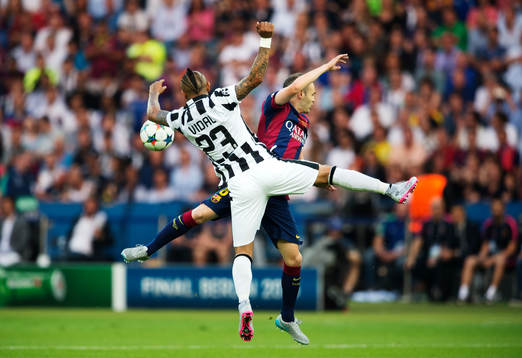 Juventus Arturo Vidal och Barcelonas Andres Iniesta i kamp