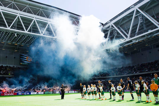 Spelarna står uppställda medans bengaler tänds
