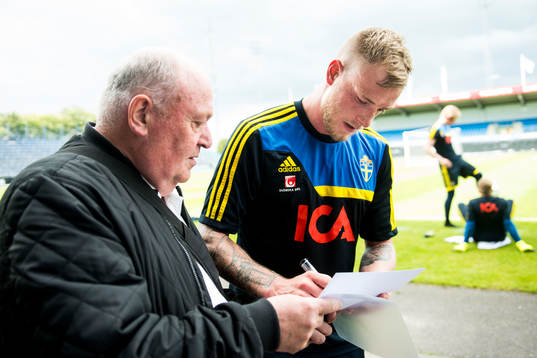 Sveriges John Guidetti skriver en autograf