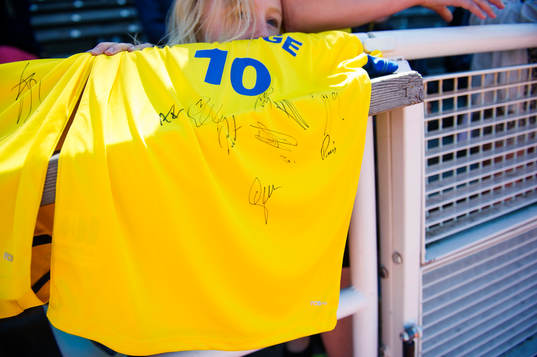 En flicka har en tröja med autografer från dom svenska