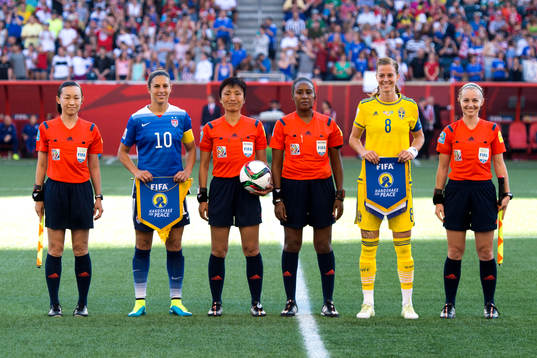 s Carli Lloyd och Sveriges Lotta Schelin med domarna innan