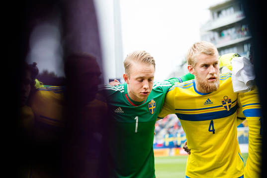 Sveriges målvakt Patrik Carlgren och Filip Helander samlas