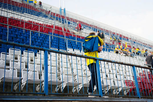 En svensk supporter plockar ner sin flagga och går hem