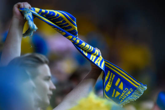 Svenska supportrar med halsduk före fotbollsmatchen i