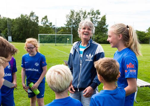 Sveriges förbundskapten Pia Sundhage ser glad ut omgiven
