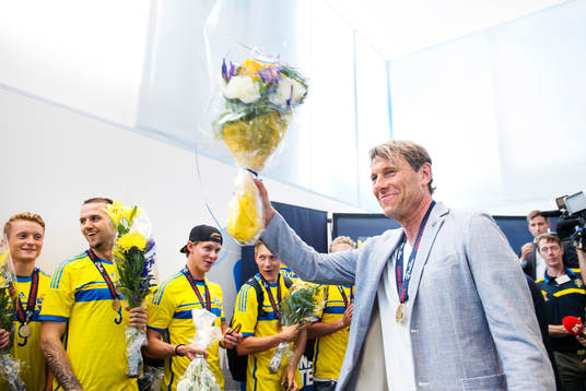 Förbundskapten Håkan Ericson håller upp en bukett blommor